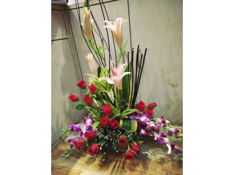 Red rose with white lilies filled with orchids 